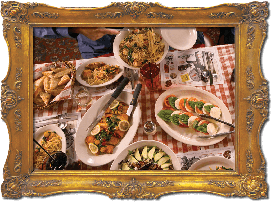 Buca di Beppo italian Restaurant, The At of Family Style Dining, image of gold frame with platters of Italian Food on table